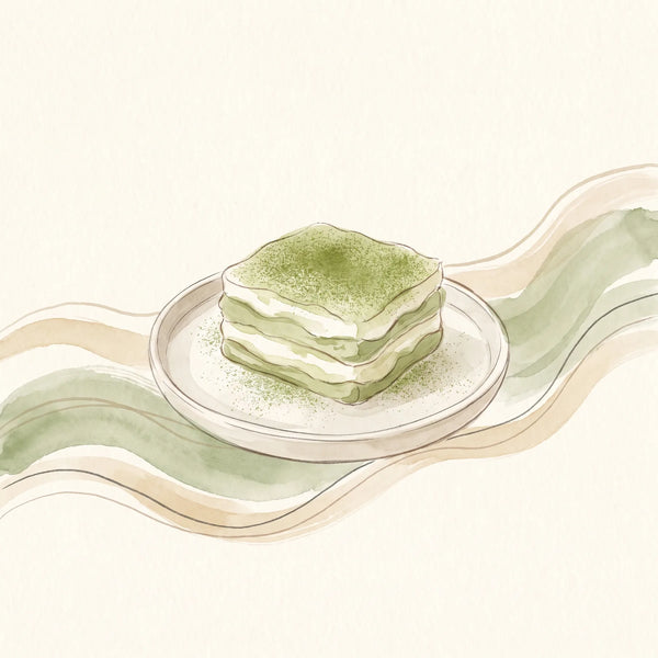 Tiramisú de matcha en un molde rectangular, con capas de bizcocho y crema, espolvoreado con matcha verde
